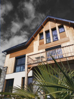 Façade maison bois avec bardage enduit et pierre